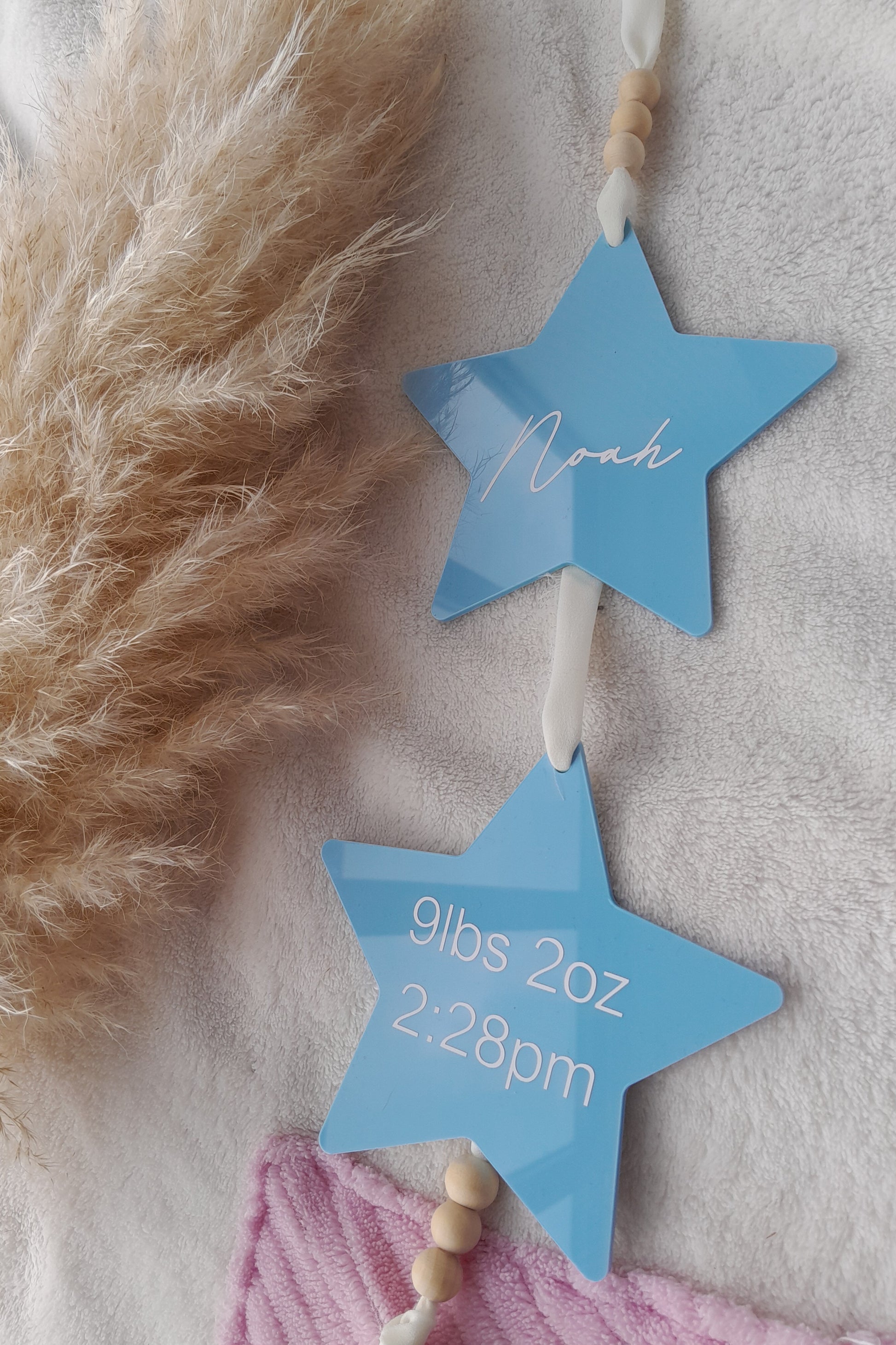 Acrylic Hanging star baby sign for nursery. 2 stars hung on white ribbon with wooden beads. Displays babies name, weight and time.