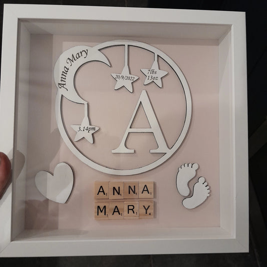 Beautiful Moon & Star wreath Frame displaying baby's name, date of birth, weight and time. Made from 3mm white mdf and set on a baby pink or blue/green background.